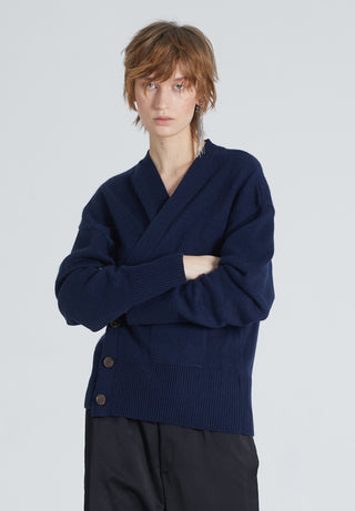 Woman wearing Luxury cashmere cardigan in Navy. Buttoned, timeless, versatile, and sustainable produced. She also wears black pants. 
