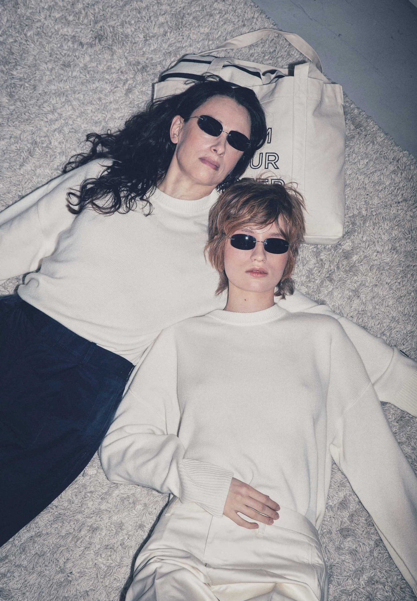 Two women, wearing matching cashmere crewnecks.