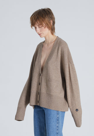 High-end brown cashmere cardigan with loose fit. Woman also wears blue jeans