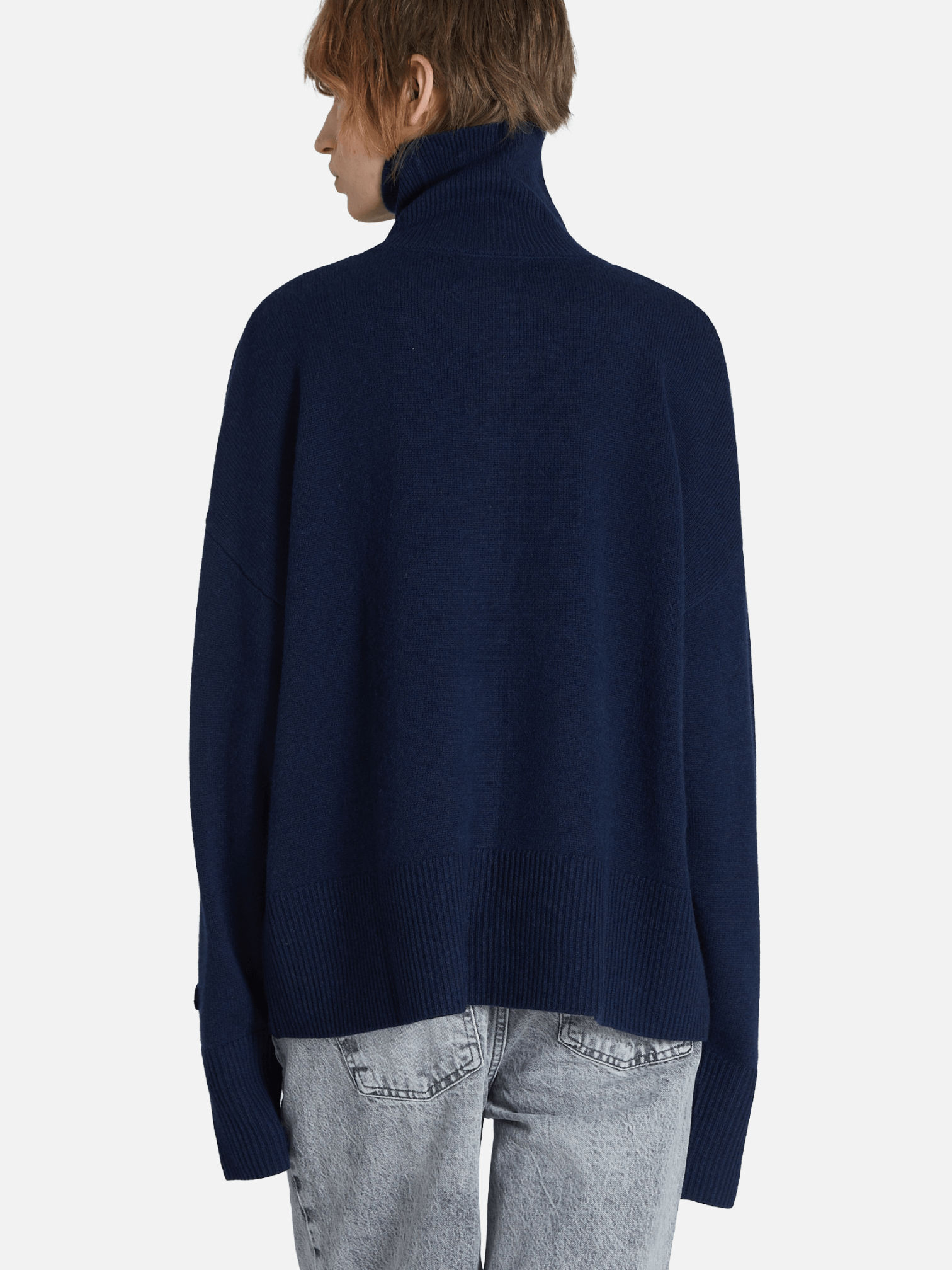 Person wearing a navy blue sweater on a white background